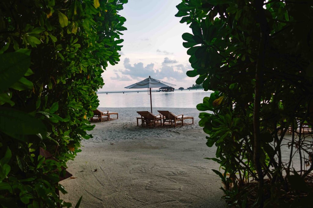 Access the beach from your beach villa in the Maldives with lounge chairs and an umbrella just for you