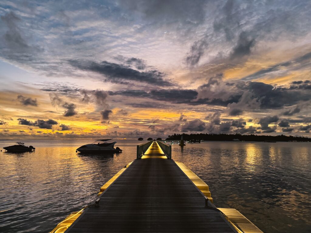 Maldives during sunset on a cloudy evening with boardwalk front and center