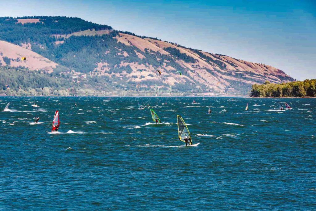 View of a bunch of windsurfers along a river that borders Oregon and Washington