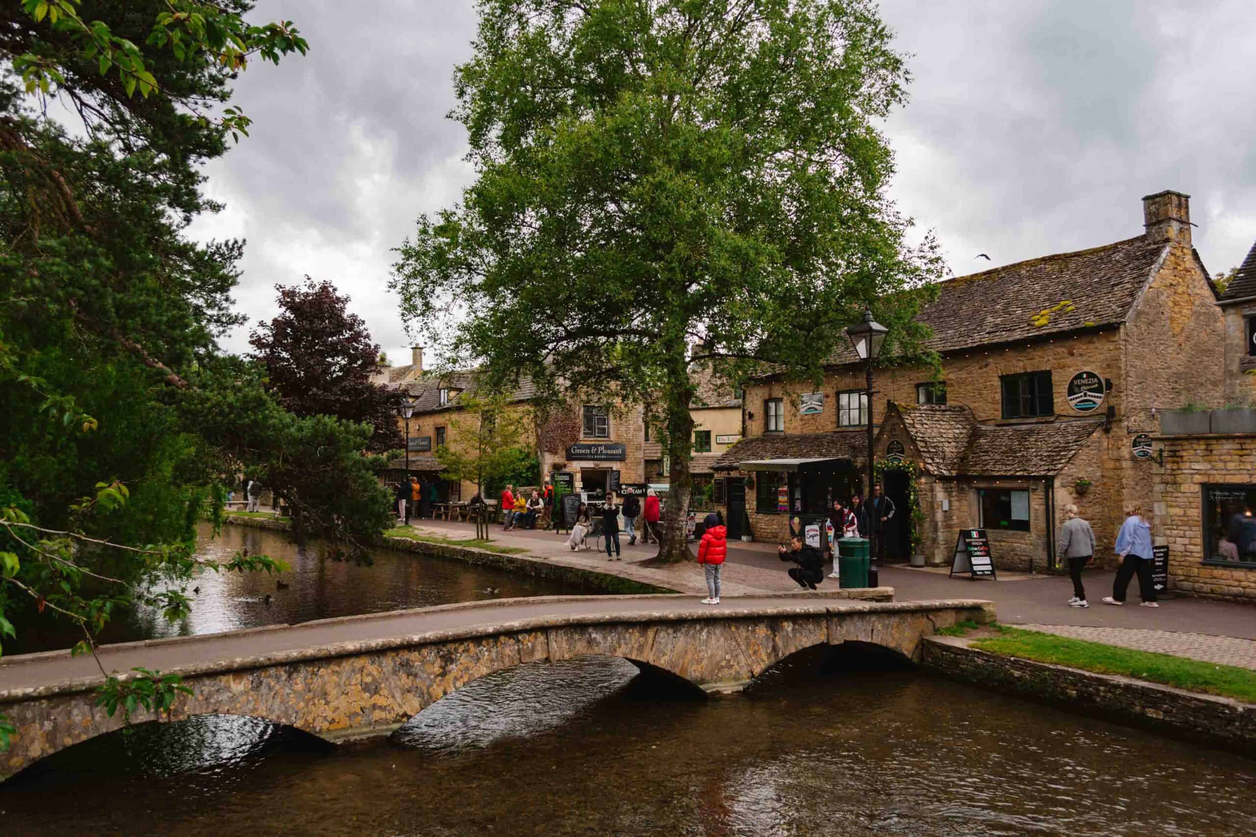 Little footbridge over the water with stone buildings behind