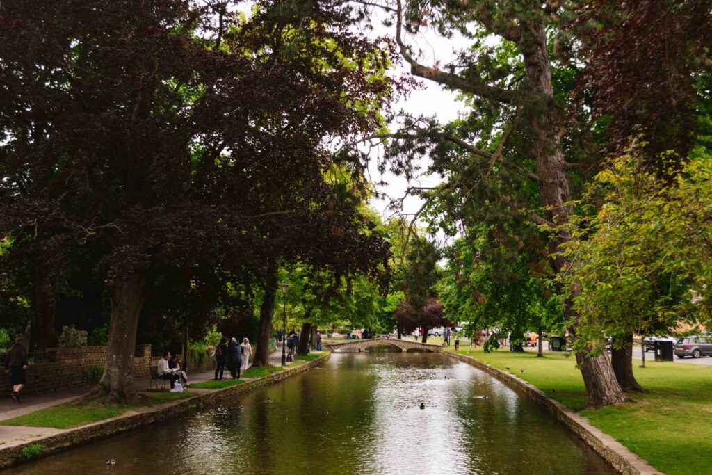 Water way running through Bourton on the Water village in The Cotswolds during summer