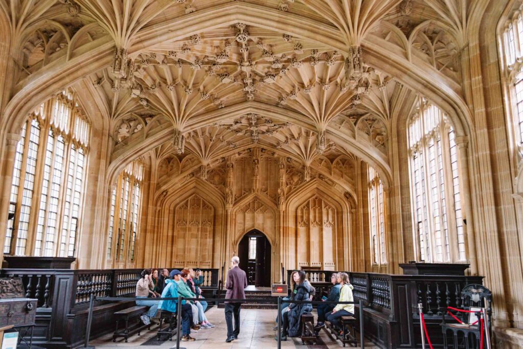 View of Oxford's Divinity School building interior looking up at the ornate decorated ceiling.