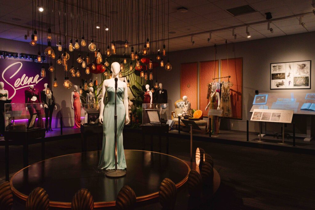 Selena movie costumes and props on display at an exhibit within Warner Brothers Studios