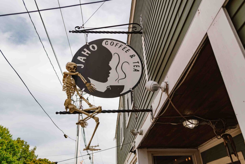 There are lots of coffee shops in Salem including Jaho Coffee, where the exterior of the shop is shown here with a focus on the sign and a decorative skeleton on top