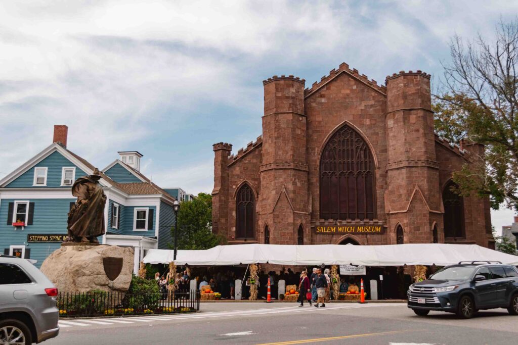 Nathaniel Hawthorne statue and Salem Witch Museum on a partly cloudy day