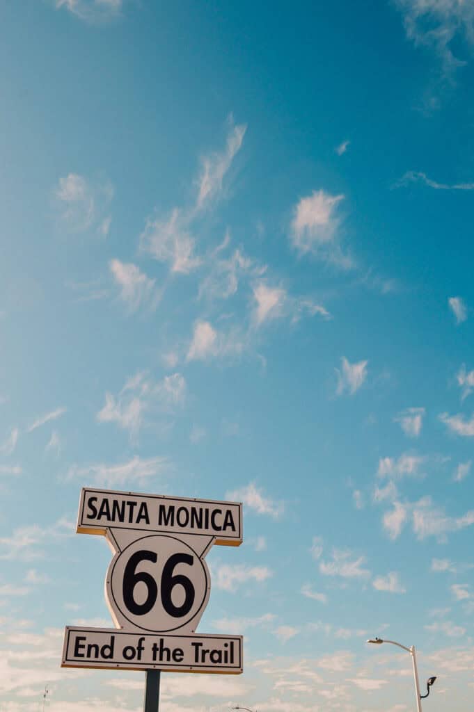 View of the Santa Monica Pier Route 66 End of the Road sign with blue sky behind