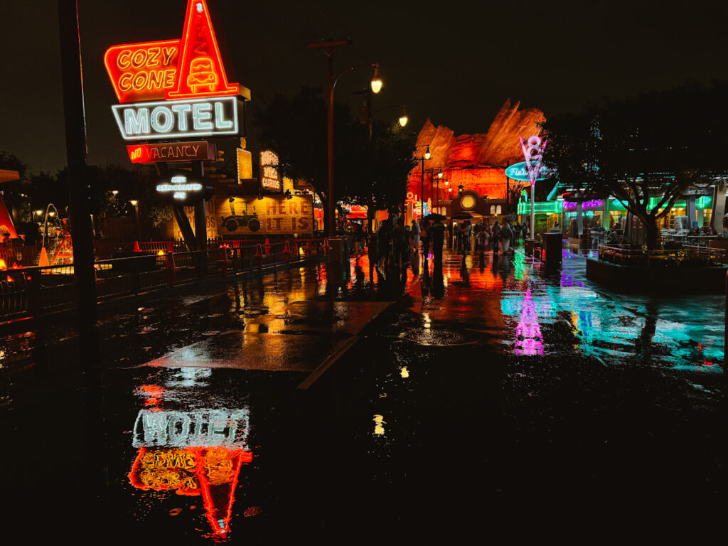 California Adventure's Cars Land in the rain at night with neon reflecting on the wet pavement