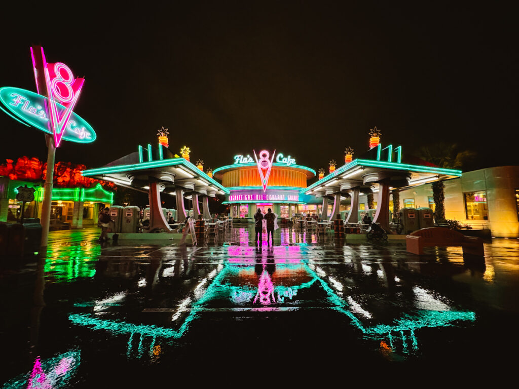 Neon reflected on the ground from Flo's Cafe in Cars Land theme park in Anaheim