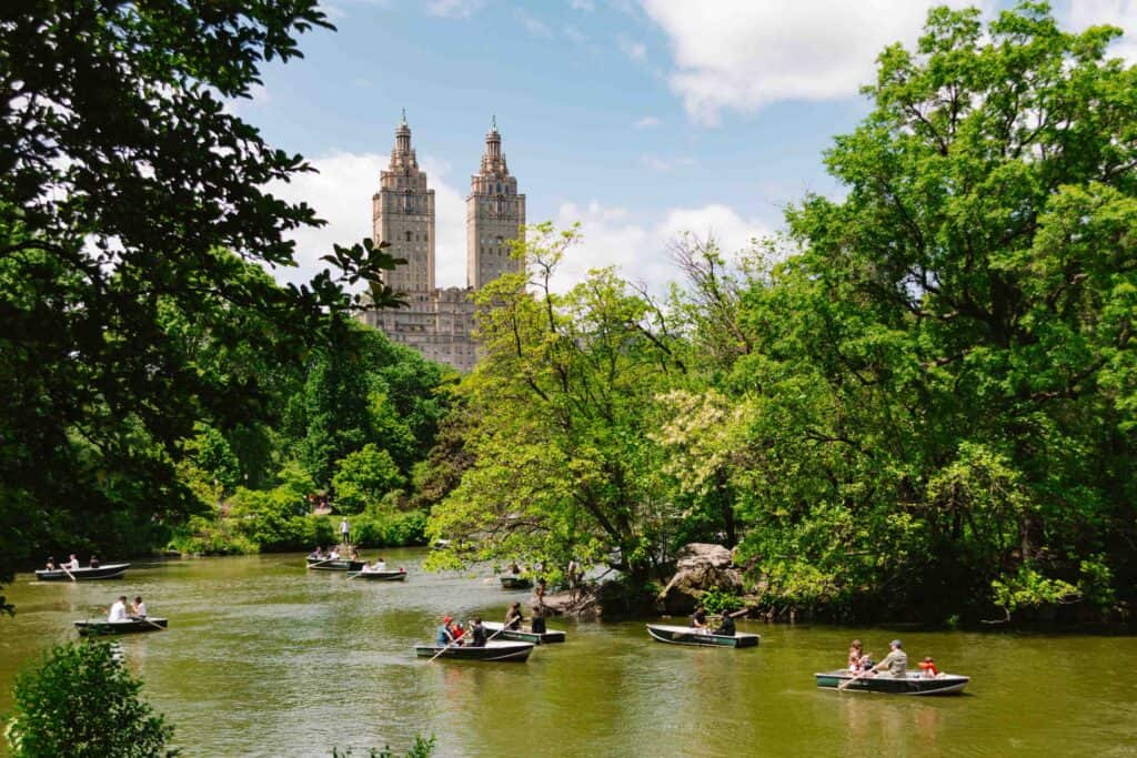 View of the Eldorado building and its two towers, through Central Park's Lake with row boats on the water