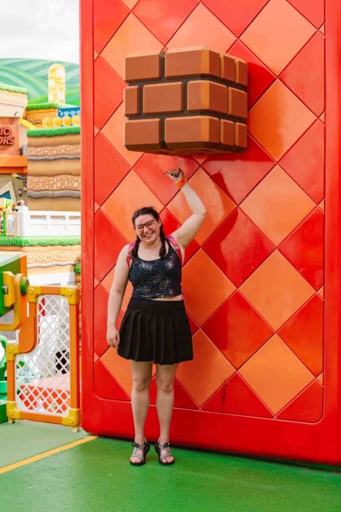 Woman standing under and punching a fake brick as seen in Super Mario games