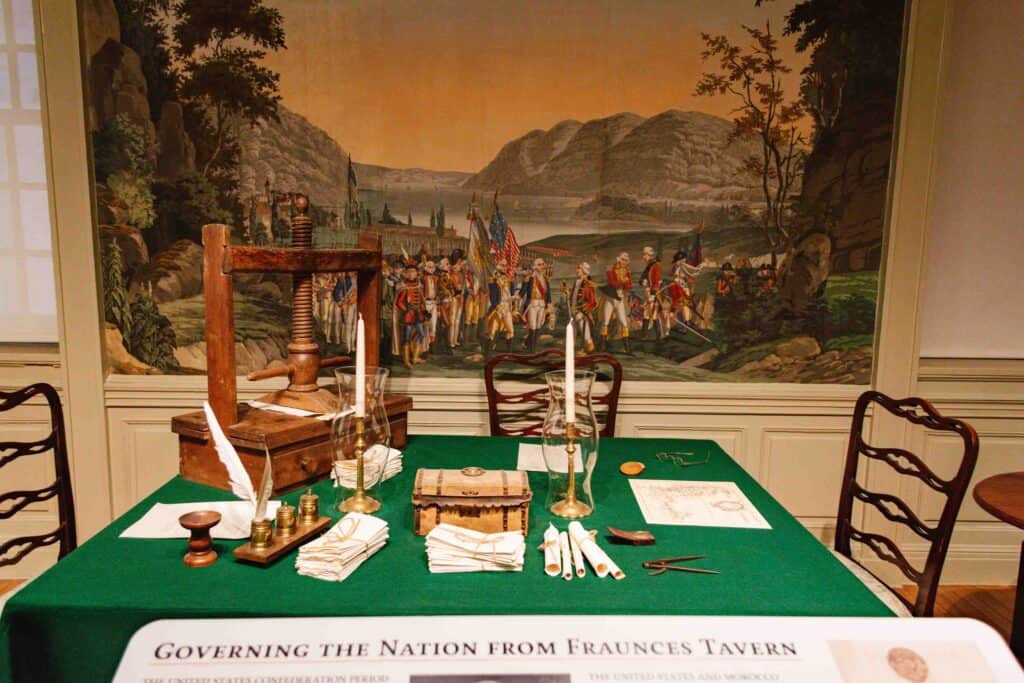 Revolutionary War era table on display with mural behind