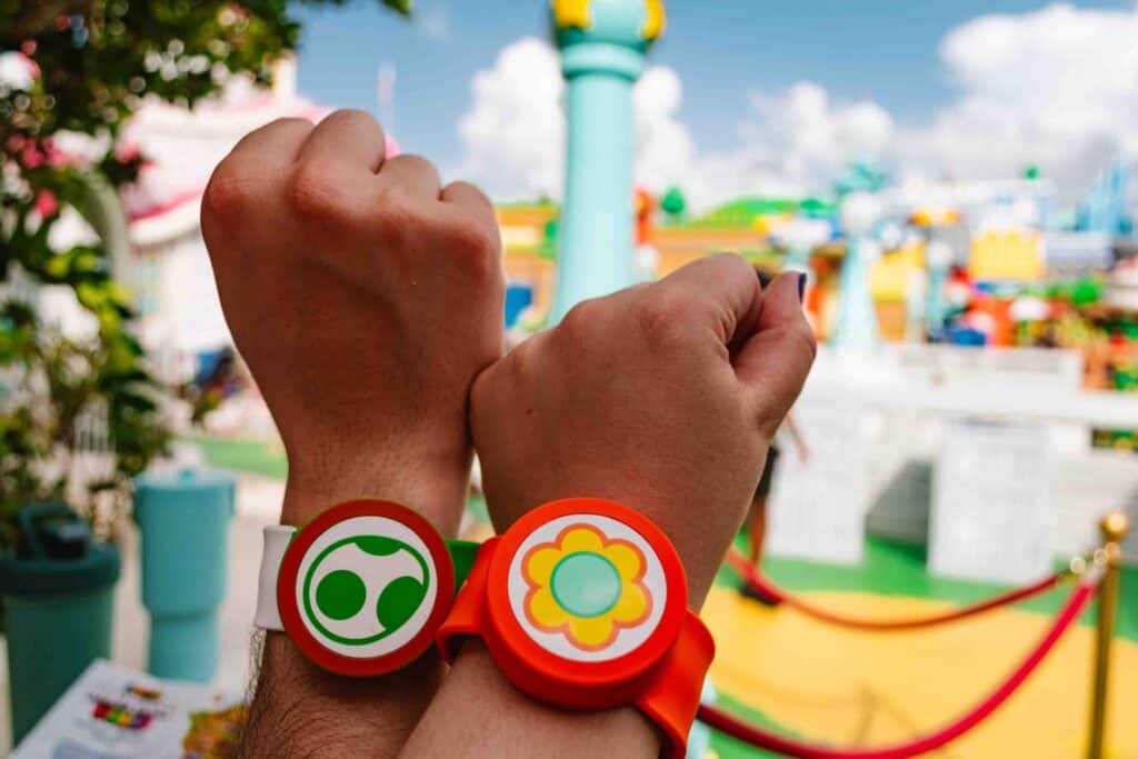 Nintendo Power Up bands on two wrists at Super Nintendo World in Orlando