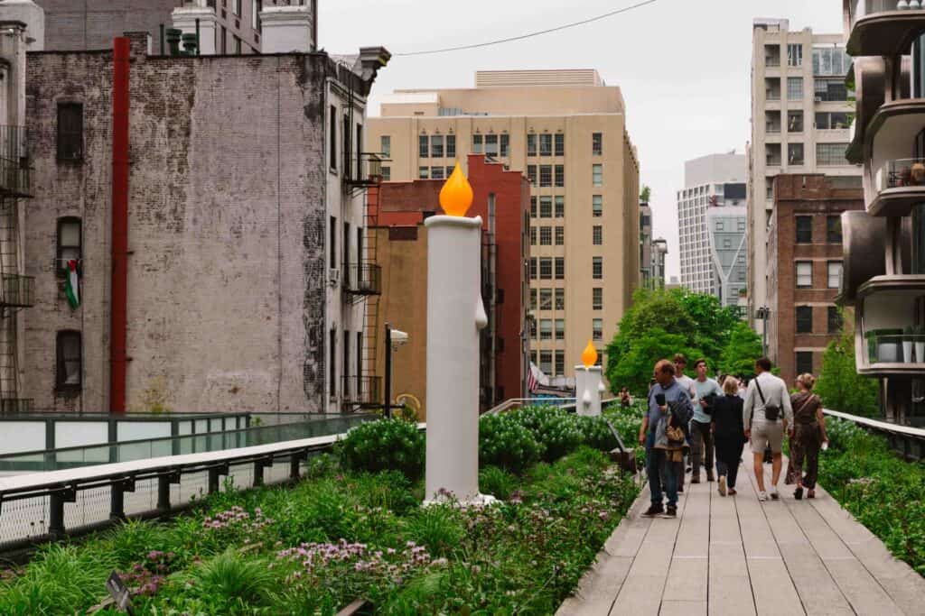 Highline in NYC on a partly cloudy day with large candlestick sculpture to the left