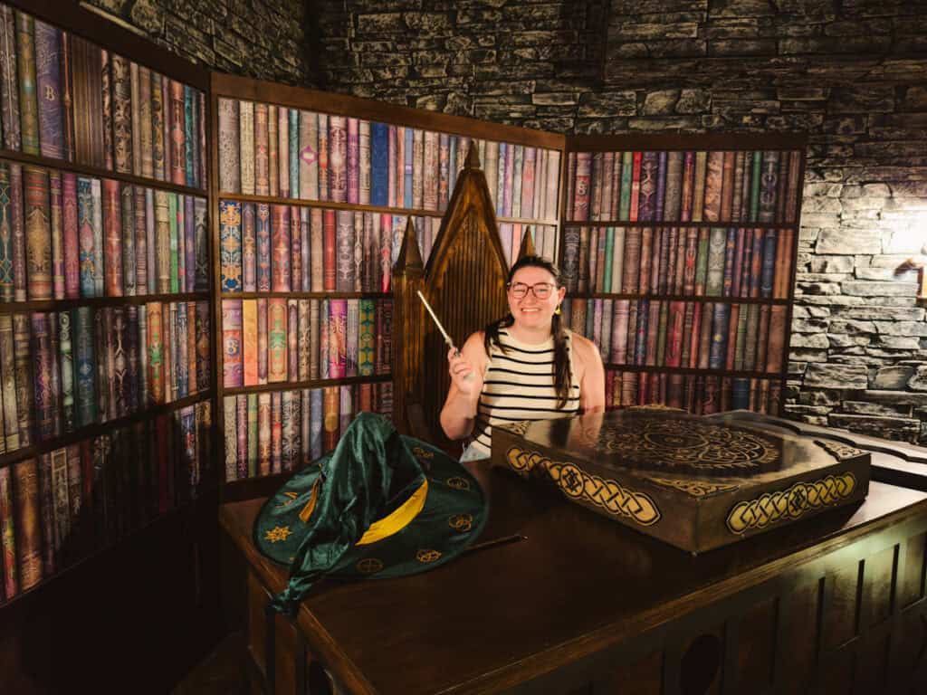 Woman sitting at a "wizard's desk" in an escape room