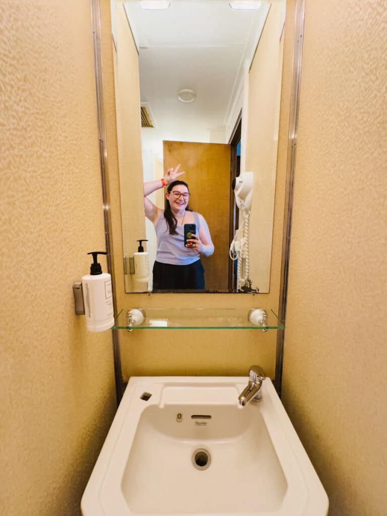 Mirror selfie in a ship stateroom bathroom, which is narrow, but manageable