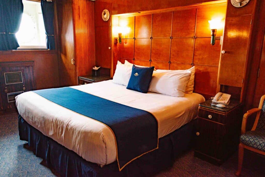 Interior of The Queen Mary wood paneled stateroom with king sized bed