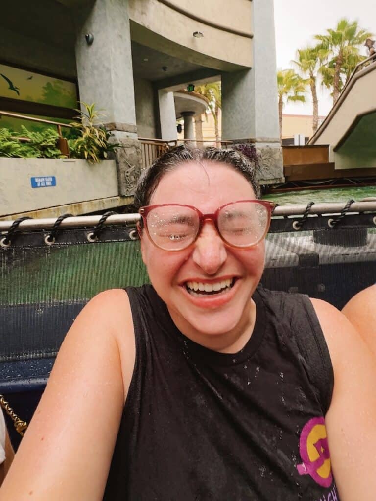Woman sitting in the back row of Jurassic World The Ride after getting soaked including her glasses