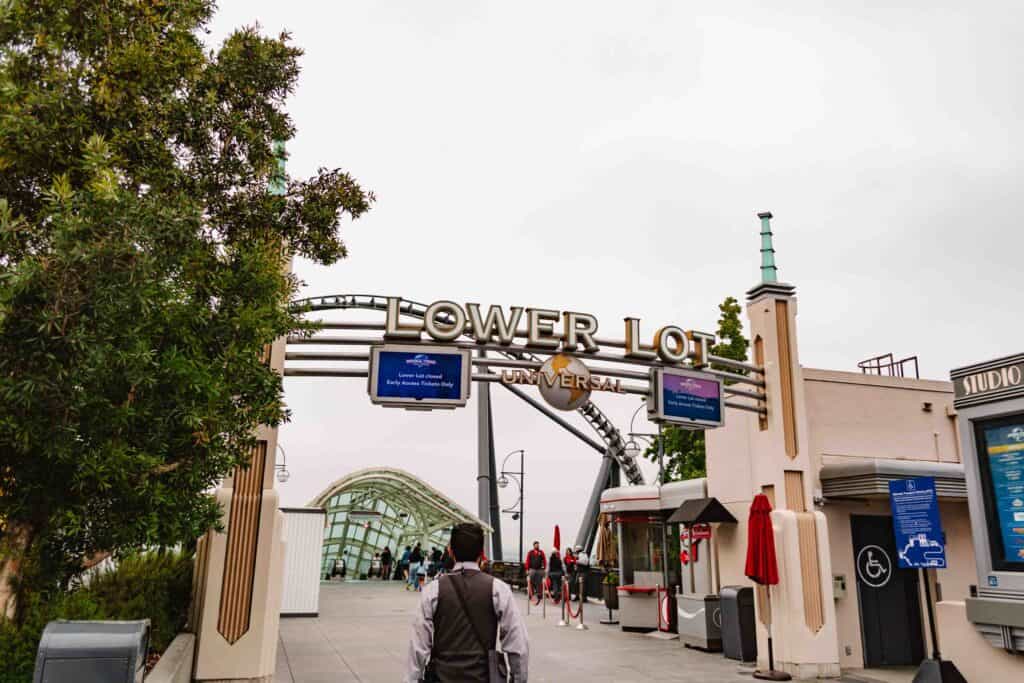 Walking in the morning to the Lower Lot at Universal Studios, where the sign overhead indicates the path ahead to the escalators leads to the Lower Lot