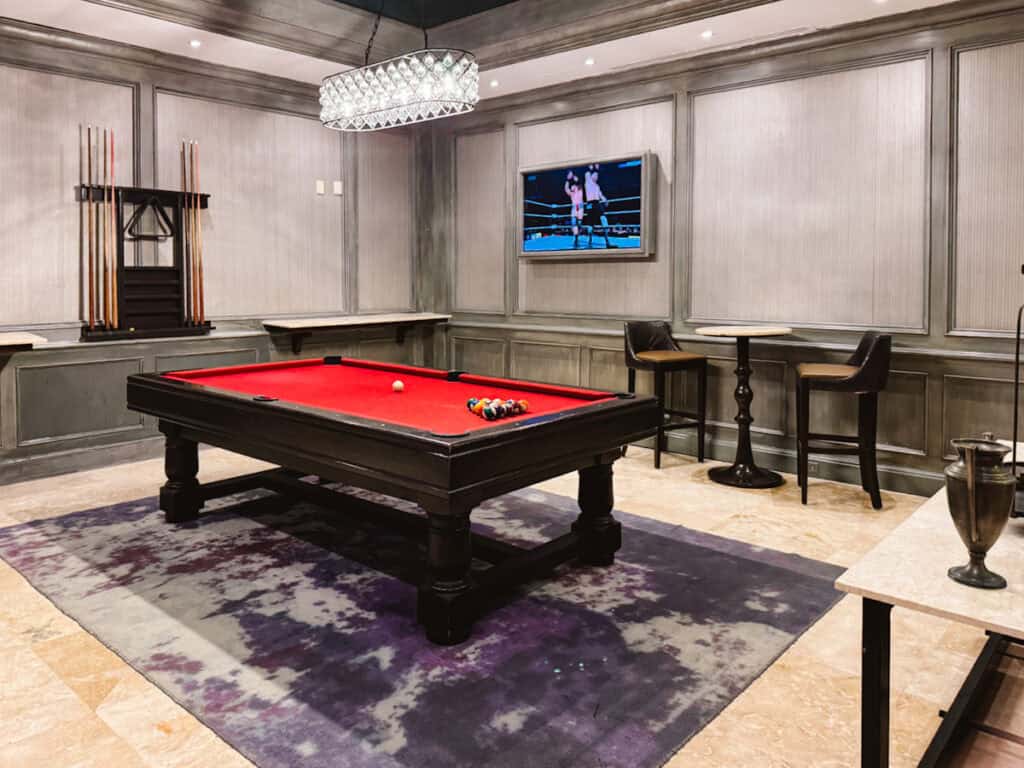Enjoy the sports bar on your vacation, where a pool table and high top chairs are shown here.