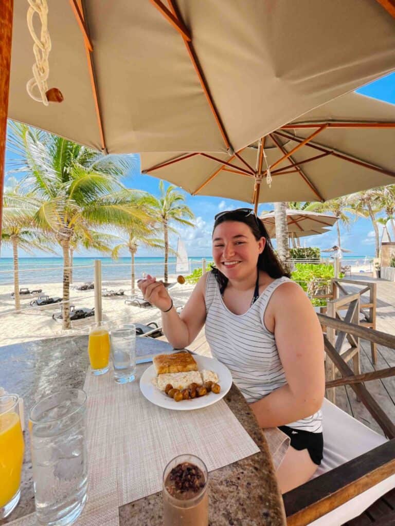 Woman enjoying her breakfast with a beach view.