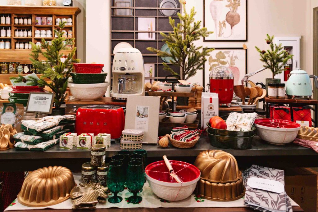 Kitchen goods store display of items for Christmas including bundt cake pans, mixing bowls, tea towels, and more.