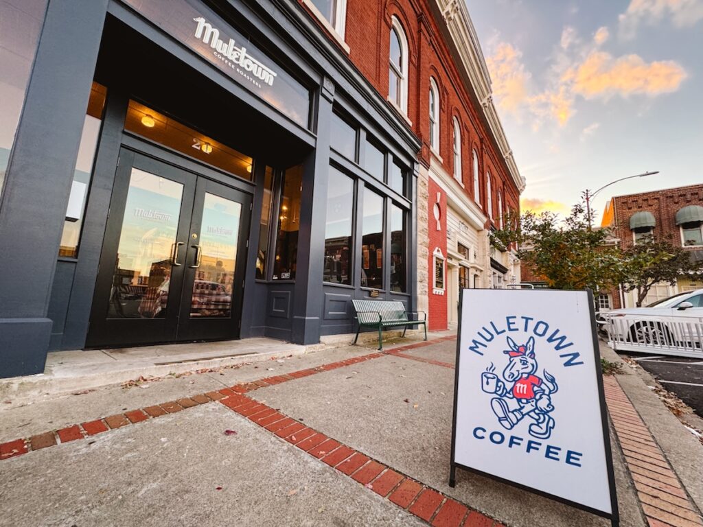 Exterior of Muletown Coffee with a labeled sign out front as well during sunset in Downtown Columbia