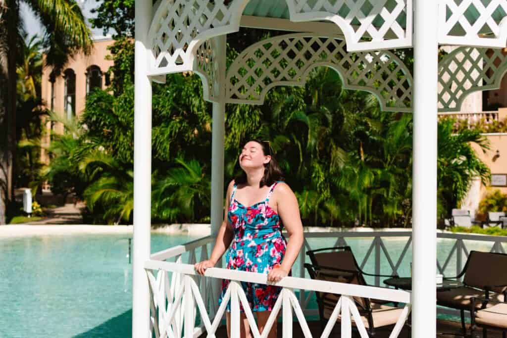 Woman standing in a gazebo with her face toward the sky and eyes closed soaking up the sun