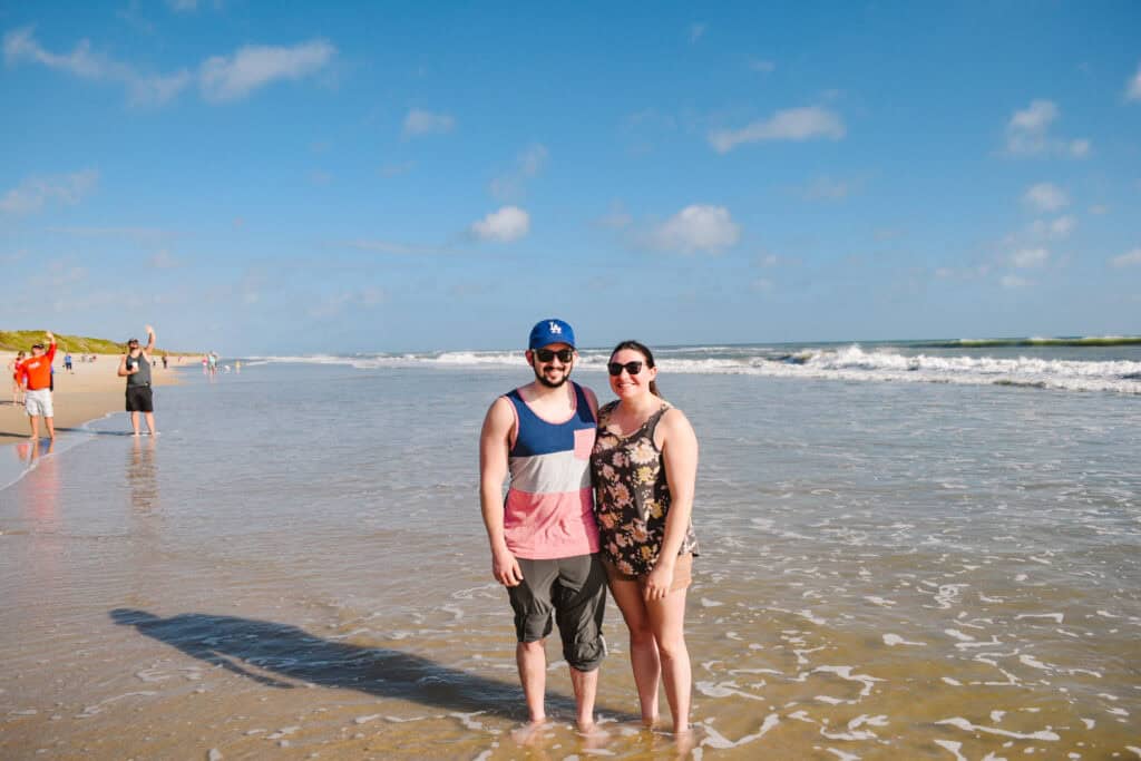 A couple smiling on a beach on Cape Canaveral National Seashore on a rocket launch day.