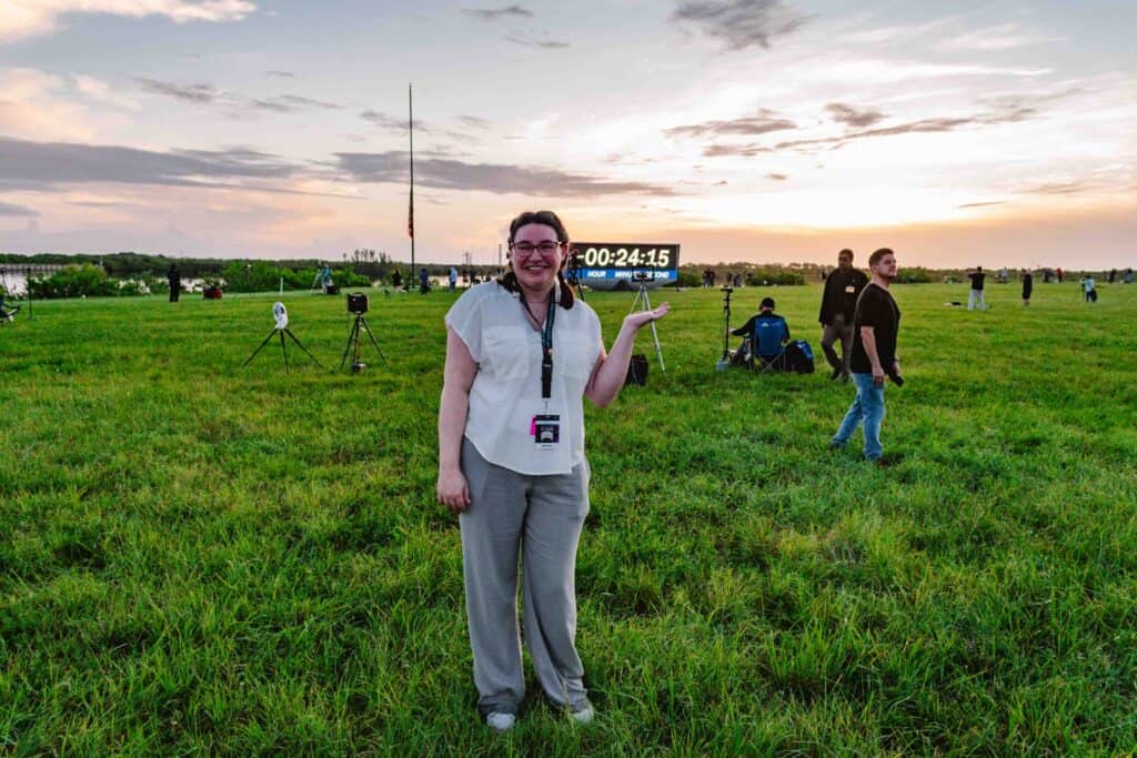 Woman pointing to a rocket launch countdown clock.